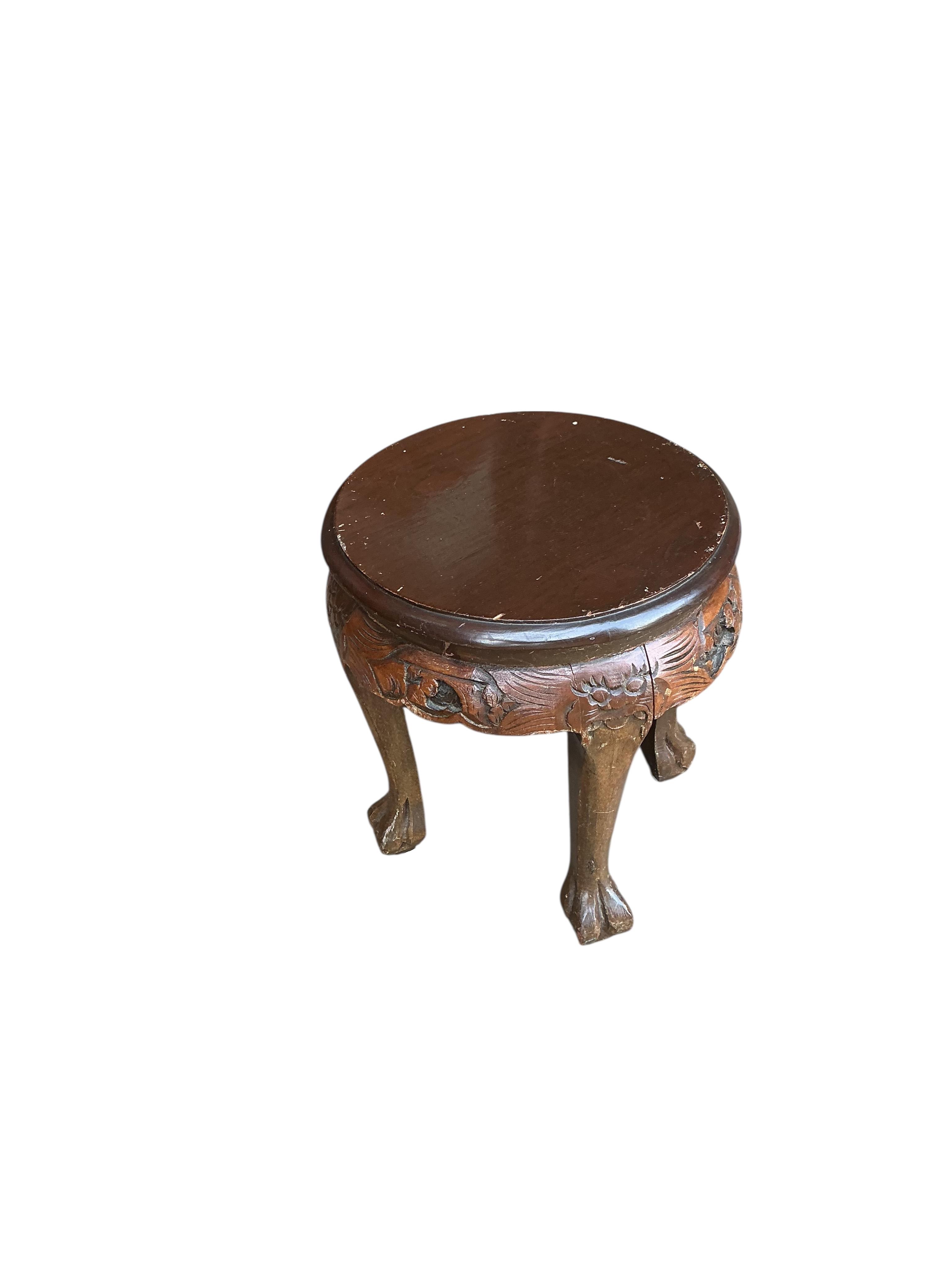 A Chinese carved hardwood circular low table, diameter 110cm, height 50cm and five stools